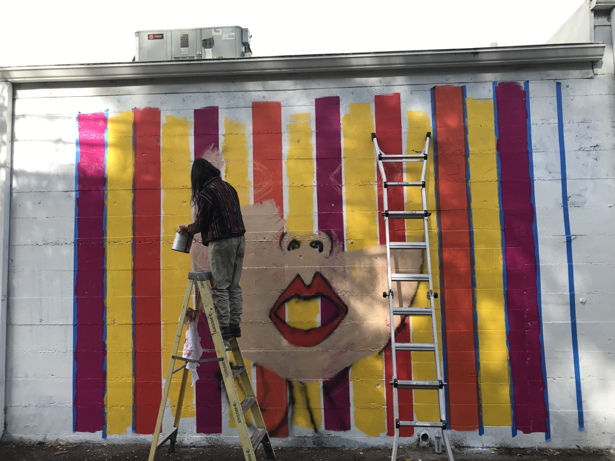 painting mural female face on striped background sacramento mural contest