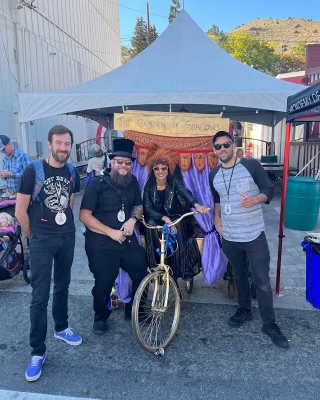 four people posing in front of outhouse virginia city outhouse race